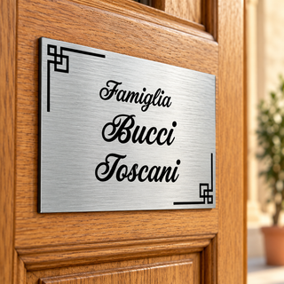 Targa nomi argentata con decorazioni geometriche su porta in legno